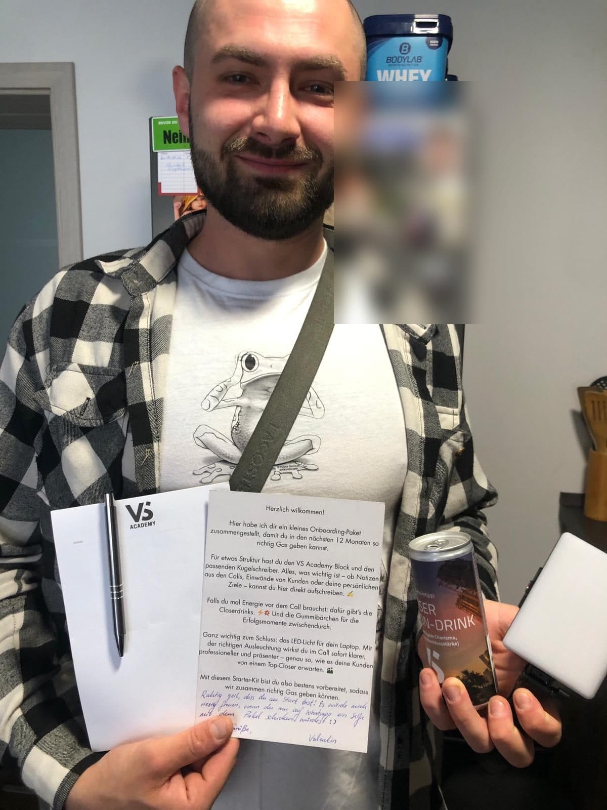 Teilnehmer hält den Willkommensbrief und eine Closer-Dose